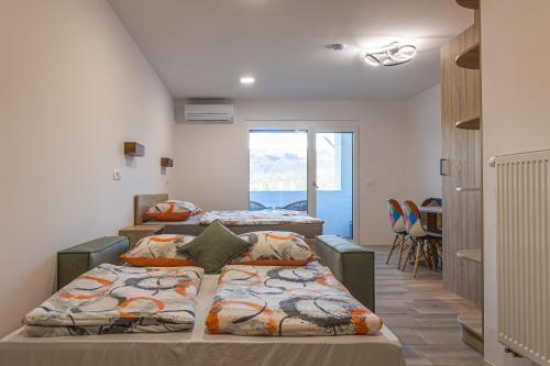 a room with three beds in a room with a window at Jazz Bled Guest House in Bled