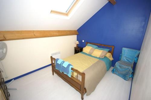 a bedroom with a bed and a blue wall at Proche de Rocamadour in Montcléra