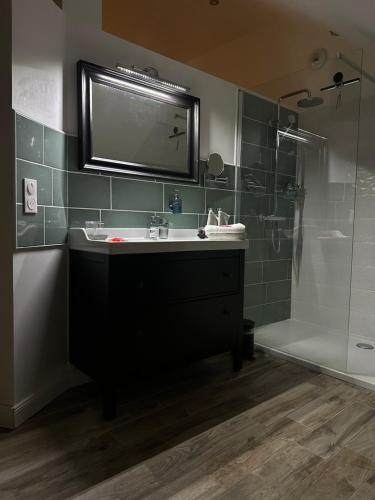 a bathroom with a sink and a shower at Sylina Spa avec Jacuzzi Privé in Villeblevin