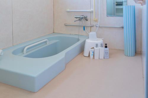 a bathroom with a blue bath tub in a room at ひなたの宿結 in Miyazaki