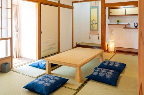 a room with a table and two blue pillows at ひなたの宿結 in Miyazaki
