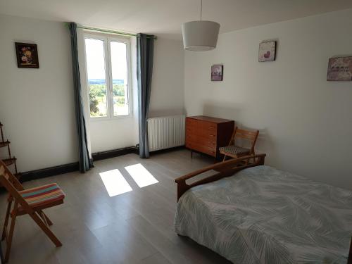 a bedroom with a bed and a dresser and a window at Gîte des deux Moulins en Périgord Vert in Grand Brassac