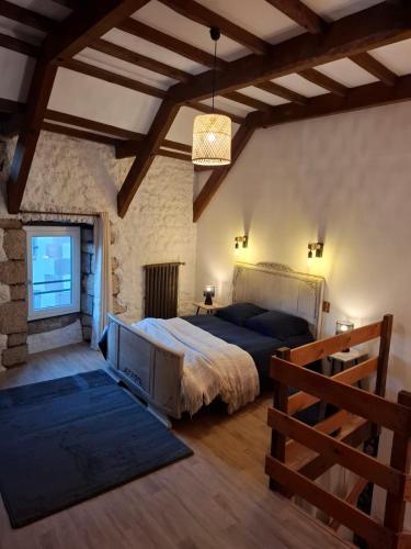 a bedroom with a large bed in a stone wall at Gite des arches in Saint-Nectaire