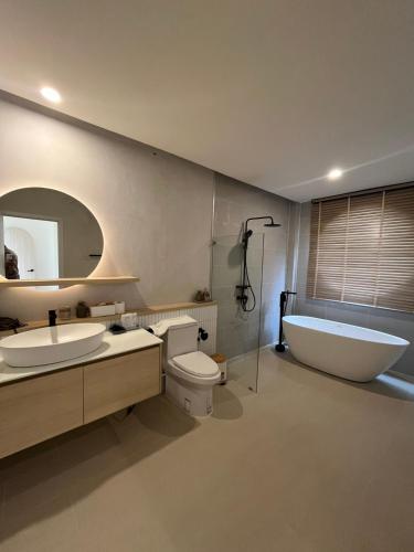 a bathroom with a tub and a toilet and a sink and a bath tub at Oxygen Cloud Khaoyai Managed by OHS in Ban Bung Toei