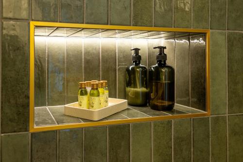 a shelf with bottles of alcohol on a wall at Lovassy Lodge Vendégház in Lovas