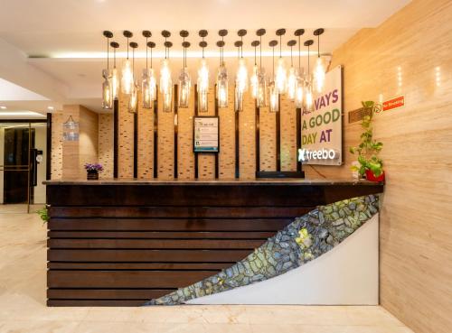 a lobby with a chandelier and a counter at Treebo Calangute Beach Stay in Calangute