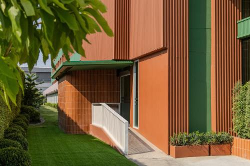 an entrance to a building with green and orange at Happihaus Hotel Bangkok in Bangkok