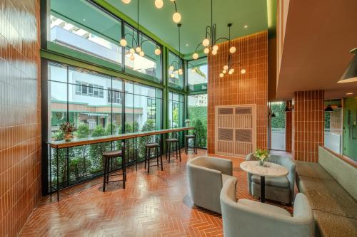 a lobby with a bar with chairs and tables at Happihaus Hotel Bangkok in Bangkok