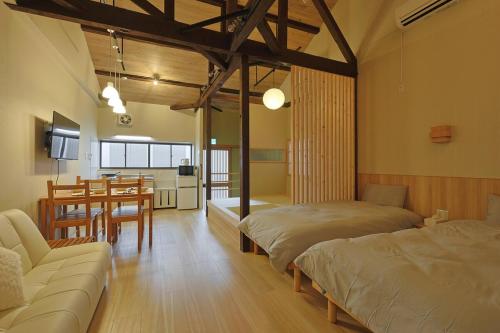 a room with two beds and a table and a kitchen at Bonju Abikomichi in Osaka