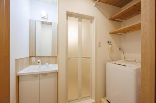 a bathroom with a sink and a washing machine at Bonju Abikomichi in Osaka