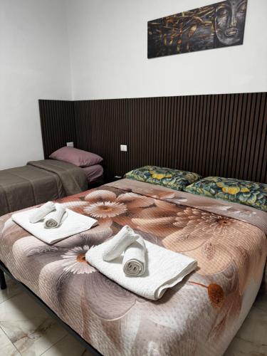a bedroom with two beds with towels on the bed at Casa Rosa in Monterotondo