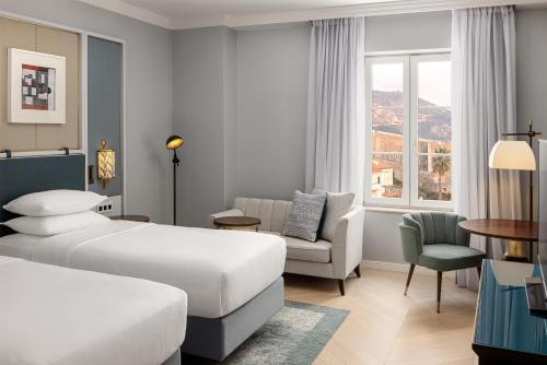 a hotel room with a bed and a chair at Hilton Imperial Dubrovnik in Dubrovnik
