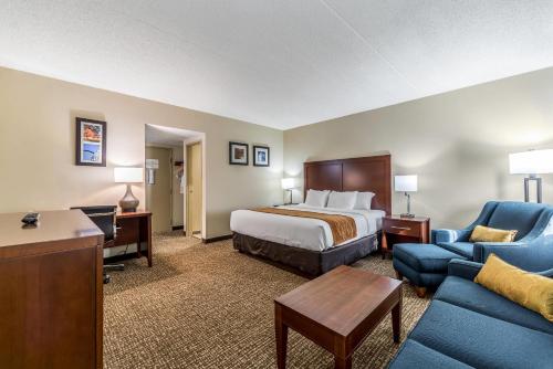 a hotel room with a bed and a blue couch at Comfort Inn Festus-St Louis South in Festus