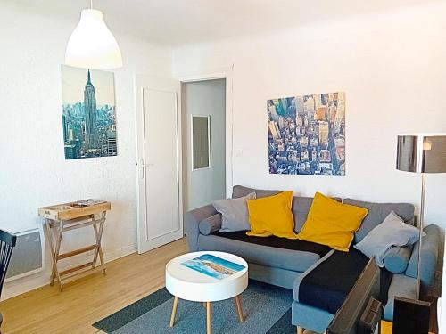 a living room with a blue couch and yellow pillows at La bonne location à HOSSEGOR ! in Soorts-Hossegor