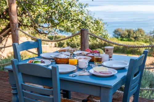 a blue table with plates of food on it at Aphrodite Family Eco Camping in Neo Chorio
