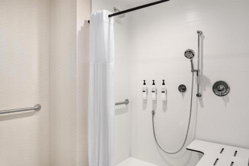 a bathroom with a shower with a shower curtain at Hilton Garden Inn Perry in Perry