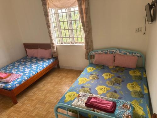 a bedroom with two beds and a window at Hotel Minh Phát in Công Thanh