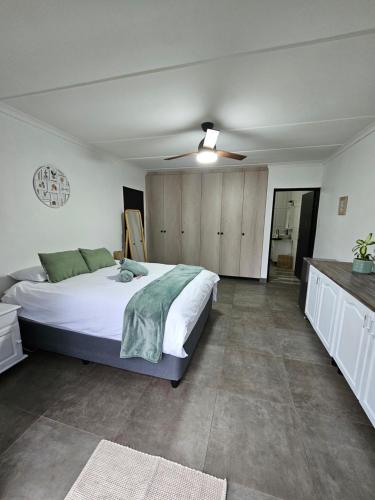 a bedroom with a large bed and a ceiling fan at Little Oasis in Hilton