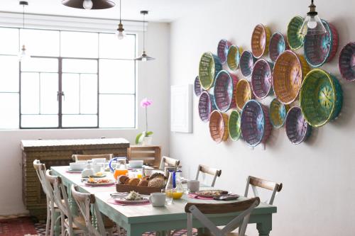 a dining room with a table with plates on the wall at La Palomilla Bed & Breakfast in Mexico City