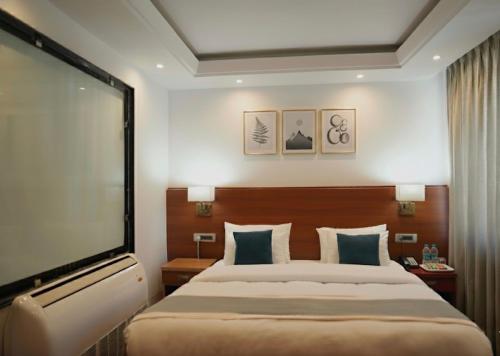 a hotel room with a large bed and a flat screen tv at Hotel The Haven Kargil - Centrally Heated in Kargil