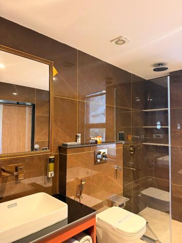 a bathroom with a shower and a toilet and a sink at Hotel The Haven Kargil - Centrally Heated in Kargil