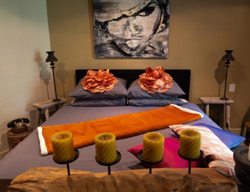 a bedroom with a bed with orange blankets and chairs at Pakhuis Bed and Breakfast Unique in Enschede
