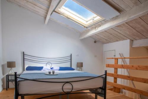 a bedroom with a bed and a skylight at Casa del Vicolo in Alghero
