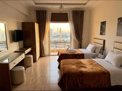 a hotel room with two beds and a balcony at Ismailia House Inn in Cairo
