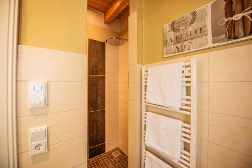 a bathroom with a shower with white towels at City-Appartements Am Wall in Goslar