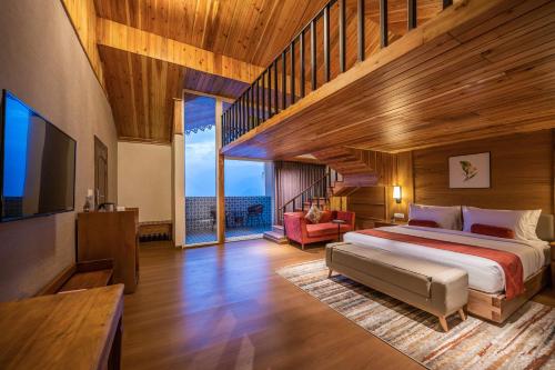 a bedroom with a large bed and a large window at Udaan Hotel Pine Crest, Pelling in Pelling