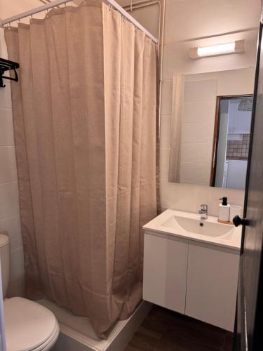 a bathroom with a shower curtain and a sink at Studio climatisé in Narbonne