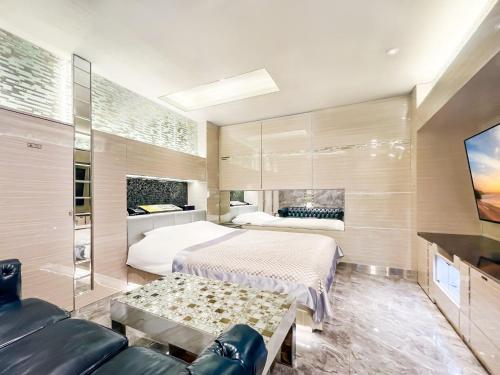 a bedroom with a bed and a couch and a tv at Hotel Century in Chiba