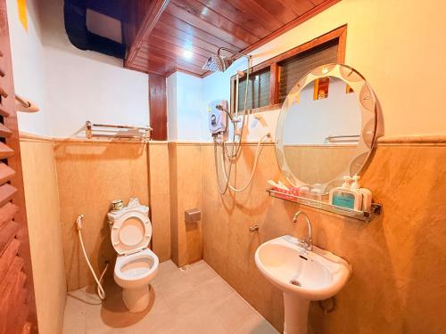 a bathroom with a sink and a toilet and a mirror at Villa Ouis NamKhan River View in Luang Prabang