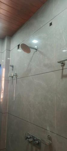 a shower in a bathroom with a tile wall at HOTEL Shiv Sai in Shirdi