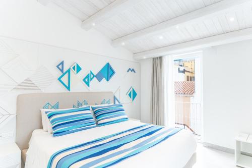 a bedroom with a bed with blue and white stripes at Luma Relais de Charme in Santa Teresa Gallura