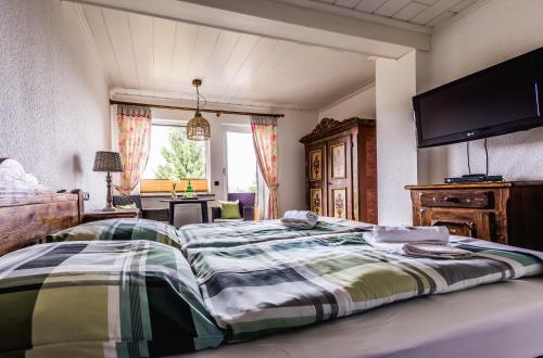 a bedroom with a large bed with a flat screen tv at Landhaus Brockenblick in Hohegeiß