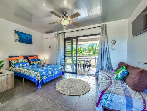 a living room with a bed and a couch at Teahupo'o Lodge Tahiti - Studio Moana, lagon et quai en face - Canoës inclus in Teahupoo