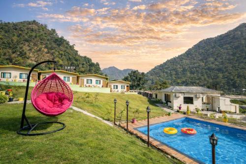 a backyard with a swing and a swimming pool at Aqua Tree Resort in Rishīkesh