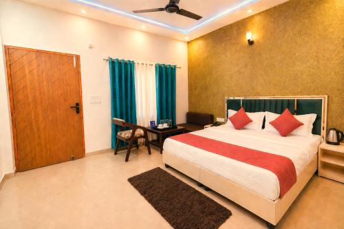 a hotel room with a bed and a table and a door at Aqua Tree Resort in Rishīkesh