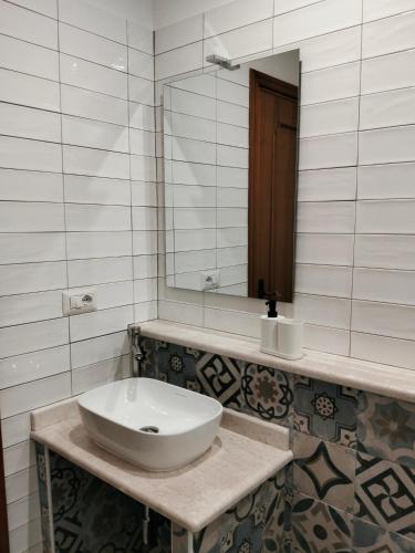 ein weißes Badezimmer mit Waschbecken und Spiegel in der Unterkunft Armoniasdecanna in Monastir