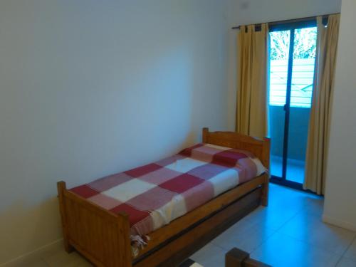 1 dormitorio con cama y ventana grande en Edificio Hipolito Irigoyen en Villa Carlos Paz