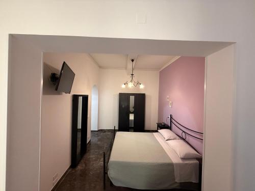 a bedroom with a bed and a pink wall at LightHouse - Casa di Luce in Reggio di Calabria