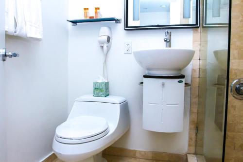 uma casa de banho com um WC e um lavatório em Dorchester Hotel & Suites em Miami Beach