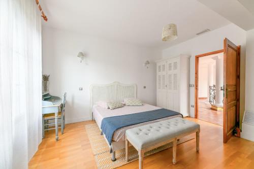 a bedroom with a bed and a table and a mirror at CoTTAGE LA VILLA BOLERO in Saint-Cyr-sur-Loire