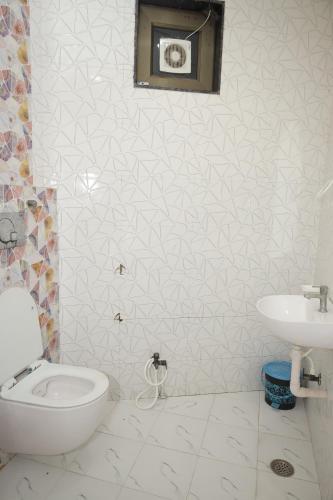 a bathroom with a toilet and a sink at Hotel SR Siddhivinayak Mathura in Mathura