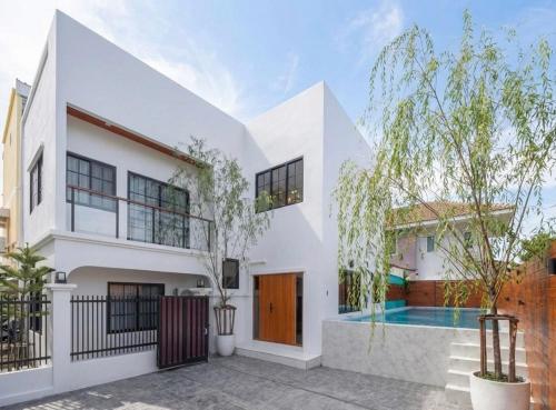 a white house with a swimming pool at Psalms 23 Residence in Bangkok