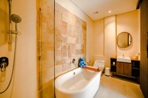 a bathroom with a tub and a shower and a sink at AMP Beach House in Nusa Penida