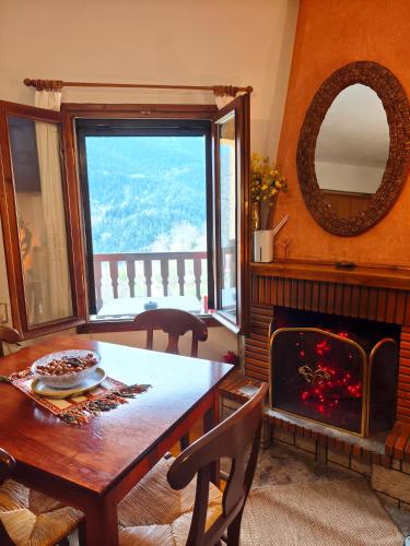a dining room with a table and a fireplace at pasithea mountain rooms in Fylaktí