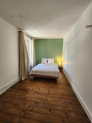 a bedroom with a bed in the corner of a room at Joli appartement T3 in Allassac