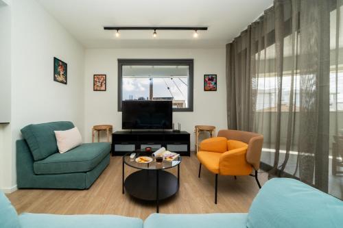 a living room with a couch and chairs and a tv at New Amazing 2 bedroom flat near casino beach mall in Limassol